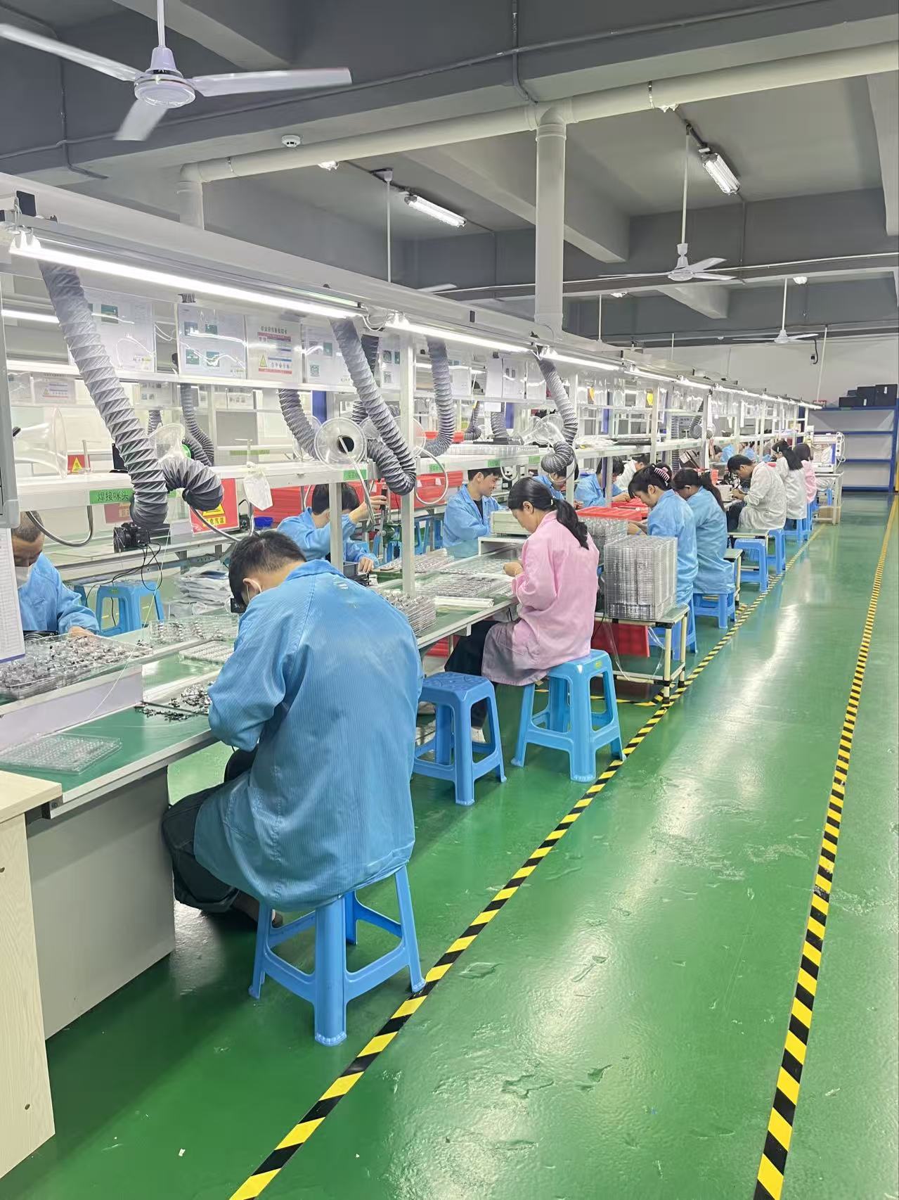 Technicians assembling smart wearable devices on the production line
