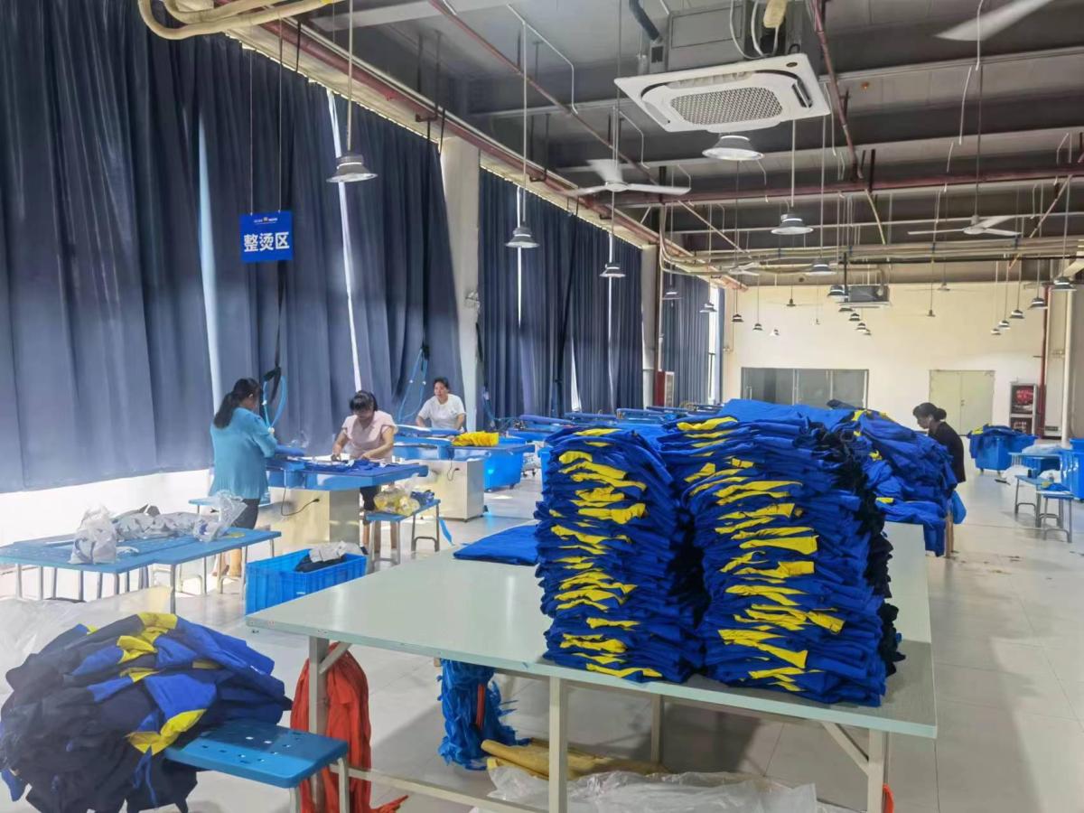 Workers preparing and organizing finished garments at packing tables