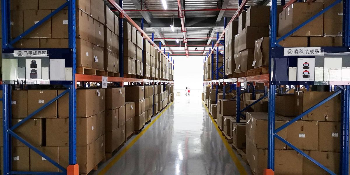 Warehouse aisle with boxed inventory stored on blue industrial racks