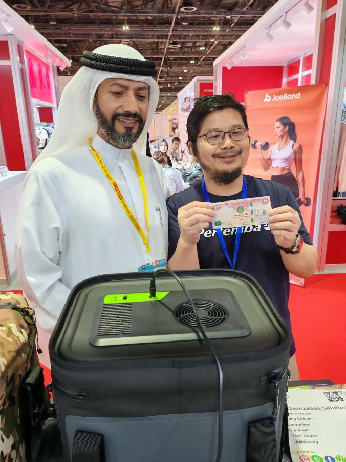 Exhibition visitor and product representative discussing a portable temperature-control bag