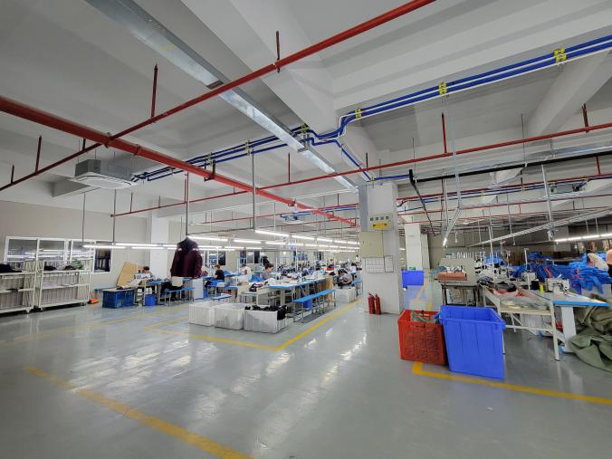 Open garment workshop floor with worktables, equipment and marked lanes