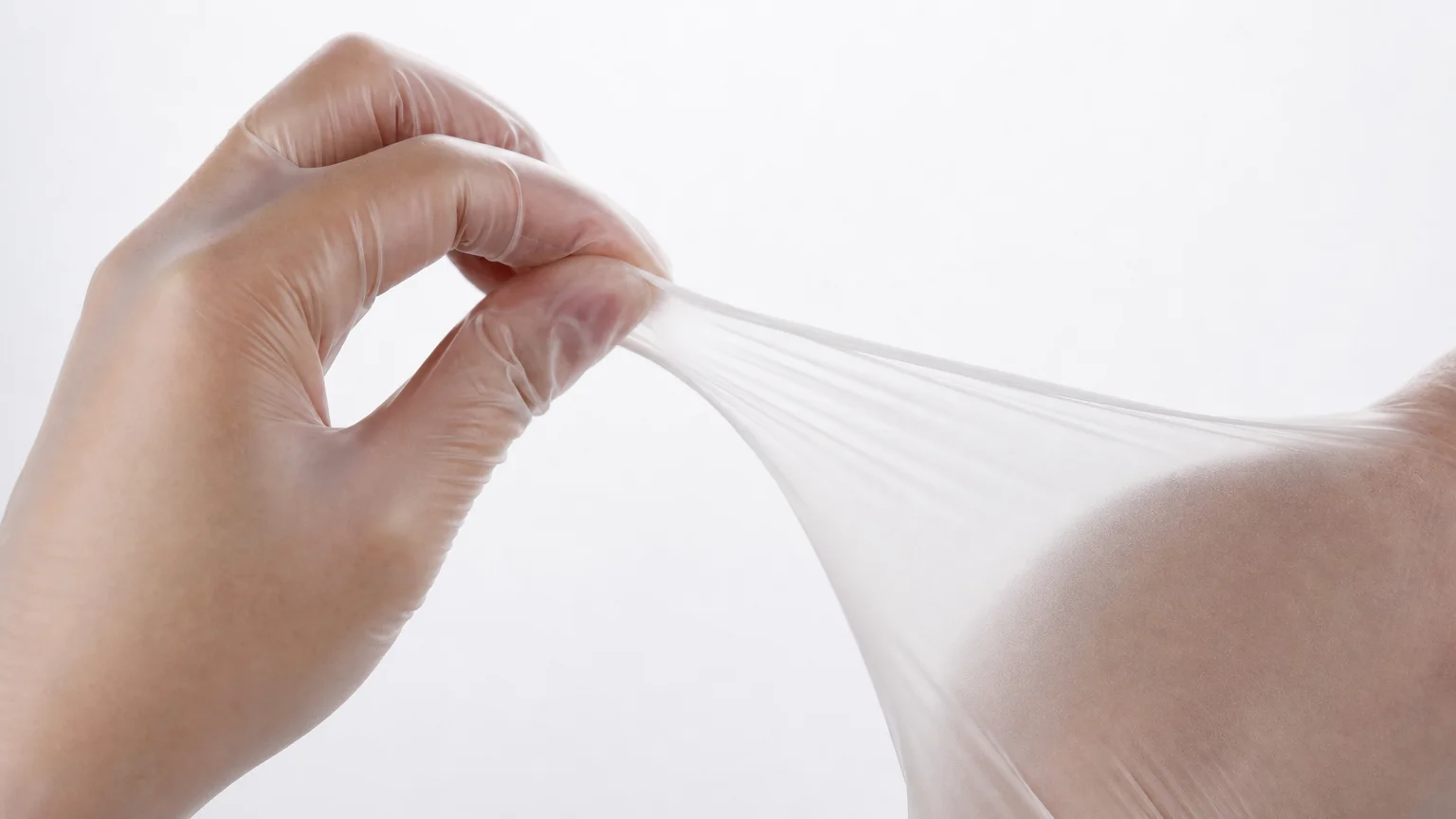 Close-up of a POE disposable glove stretched to show nitrile-like elasticity
