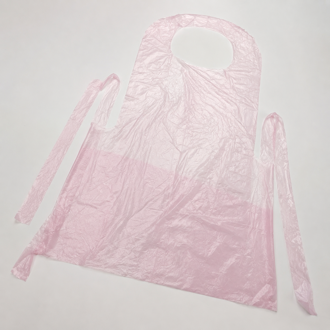 Disposable PE apron film and integrated tie construction