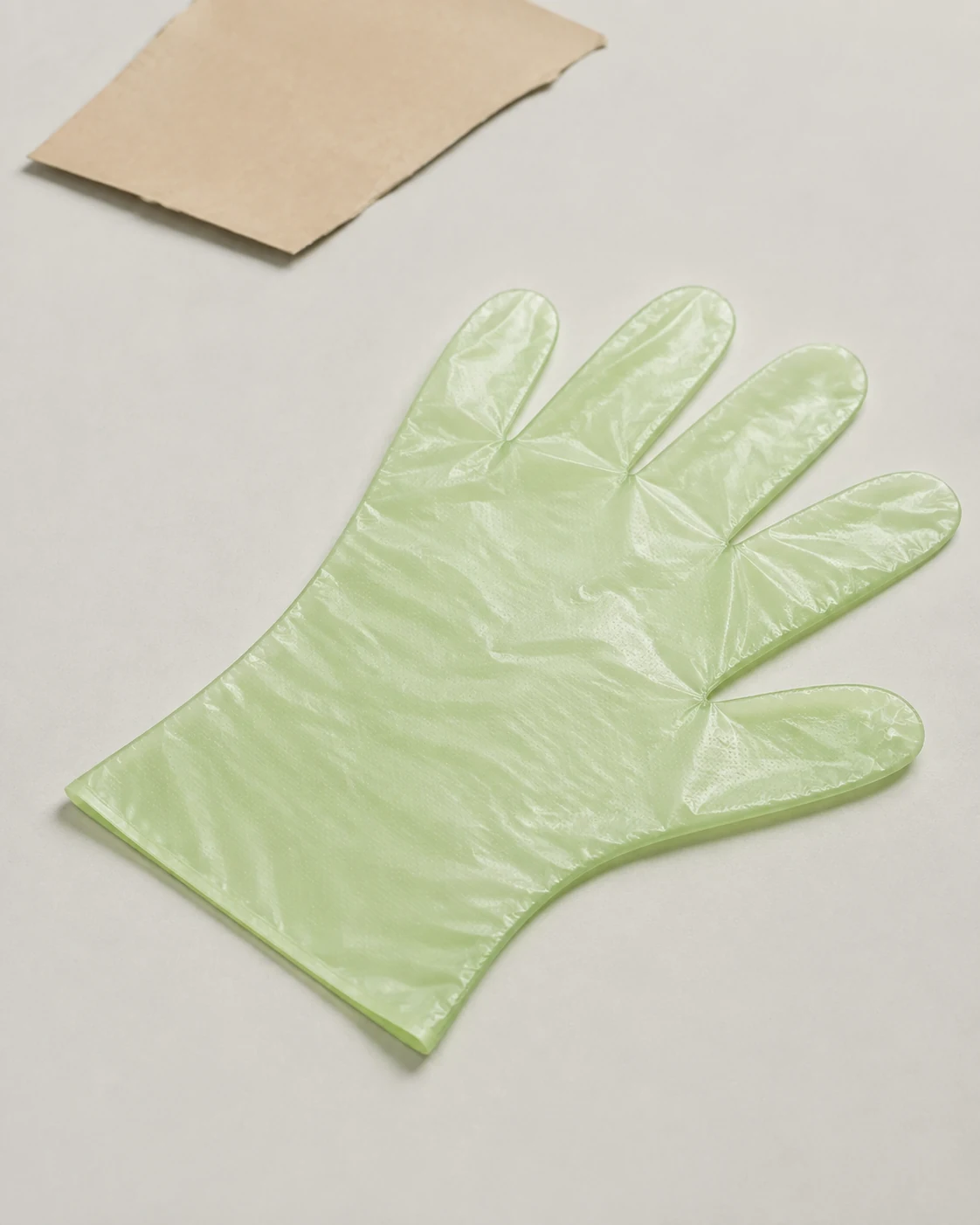 Light green biodegradable disposable film glove with a lightly embossed surface