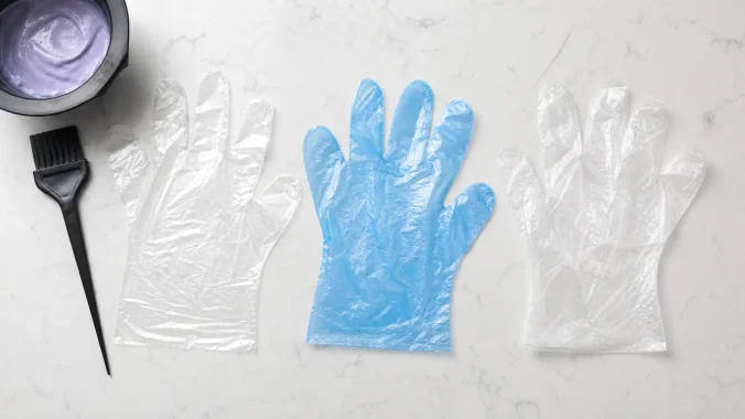 Disposable glove materials for hair coloring compared on a salon counter