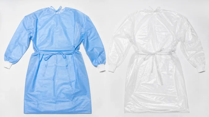 Blue CPE and clear PE isolation gowns compared side by side on a white surface