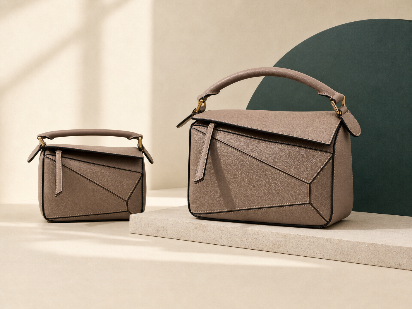 Two taupe structured shoulder bags with geometric panel construction